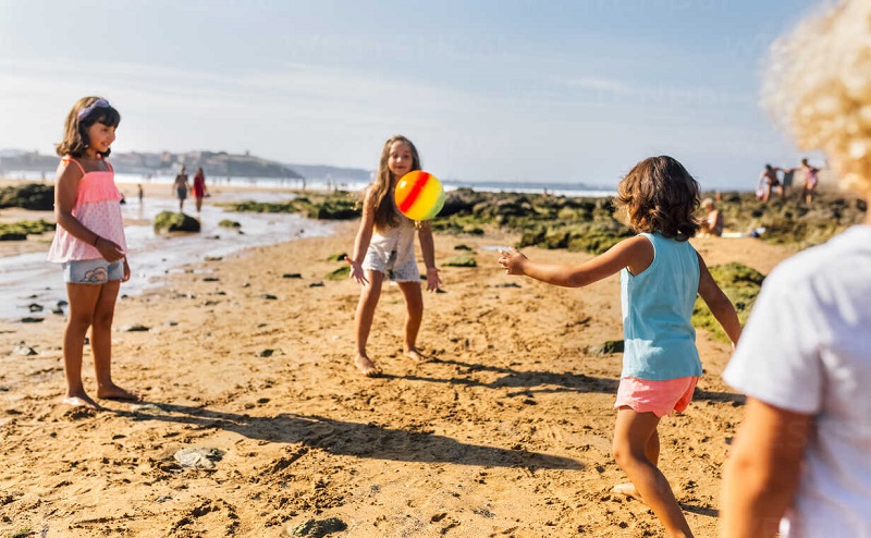 Gijón, Asturias, Spain, group of kids playing on the beach