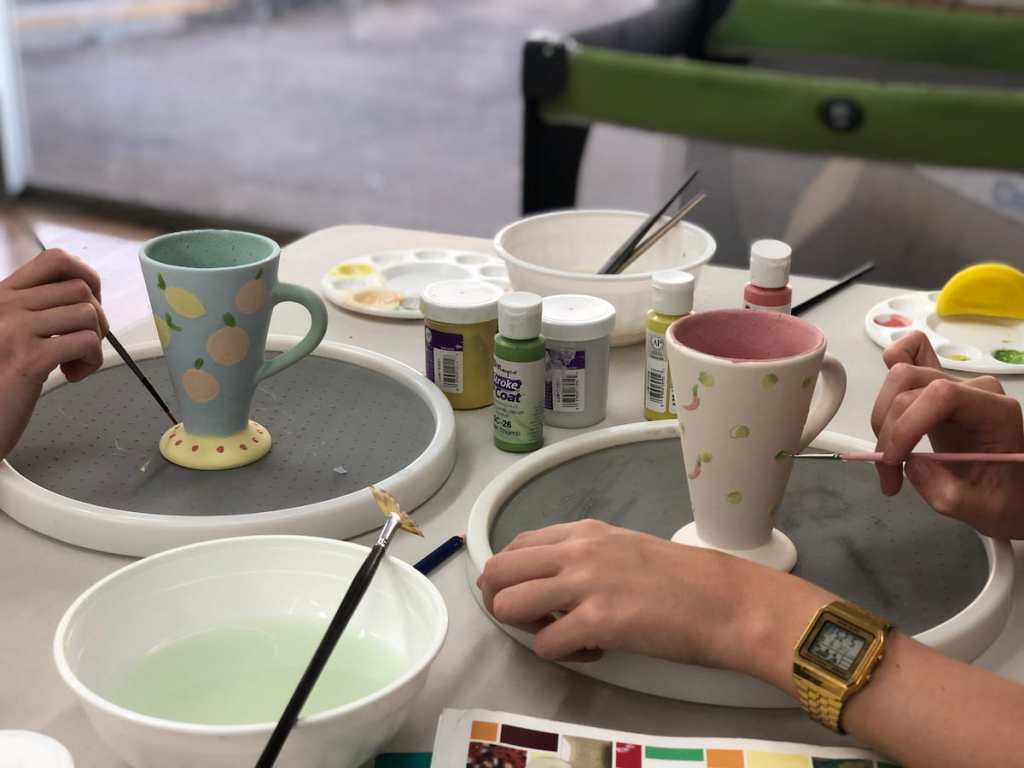 potters painting on ceramic objects